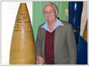 Hood veteran Jim Taylor posing next to a 15 inch shell
